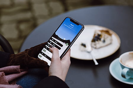 person using iPhone x near the table thumbnail