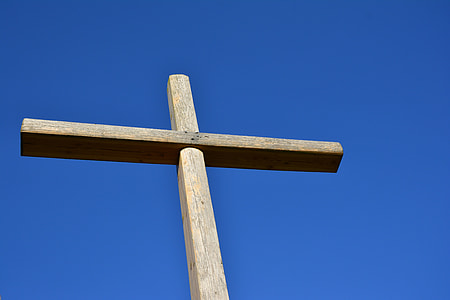 close up photography of brown wooden cross under blue cloudy sky thumbnail