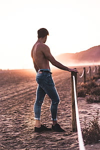 topless man standing near fence during daytime thumbnail