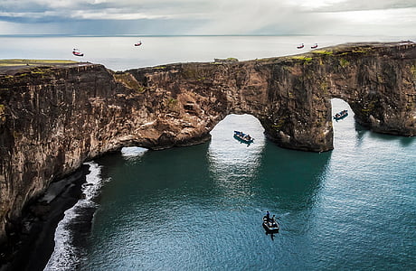 boats near rock formation thumbnail