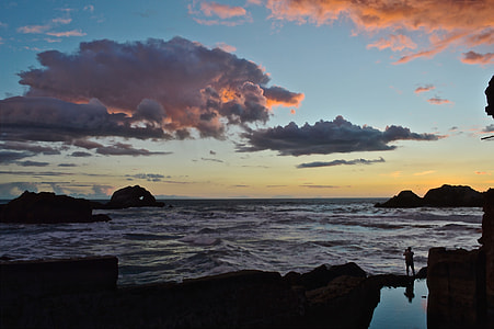 person standing near body of water silhouette thumbnail