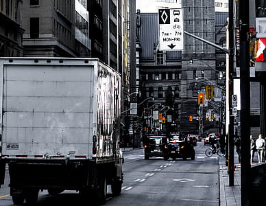 delivery truck moving toward city building thumbnail