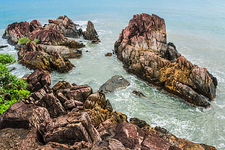 Brown Rock Formations Beside Ocean thumbnail