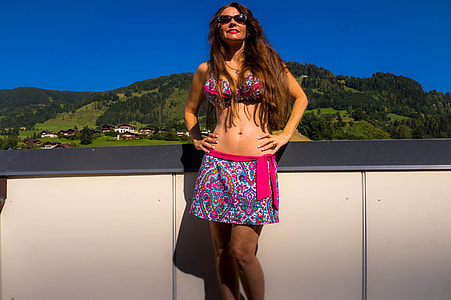 woman in multicolored bikini standing near white fence during daytime thumbnail