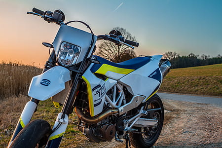 white and yellow dirt bike parked near green fields thumbnail