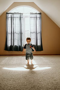Boy Wearing Gray T-shirt and Gray Cargo Shorts Inside White Painted Wall Room thumbnail