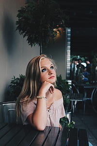 woman sitting beside table while looking up during table thumbnail