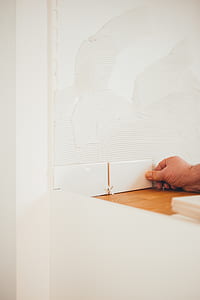 person holding white ceramic tile thumbnail