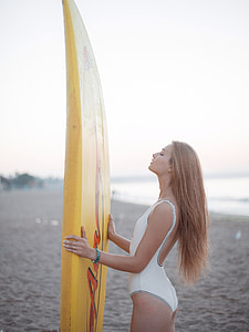 woman holding yellow surfboard thumbnail