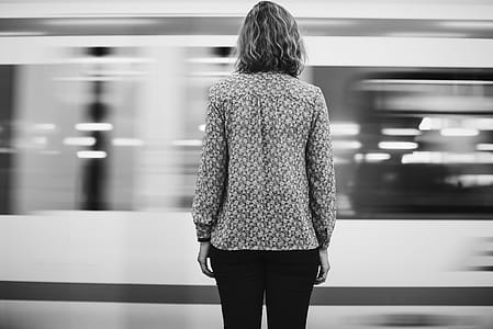 Grayscale Photo Of Woman In Front Of Train thumbnail