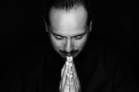 grayscale photography of man praying thumbnail