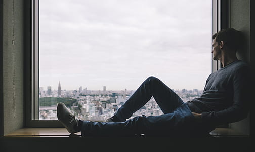 man starring beside the window pane thumbnail