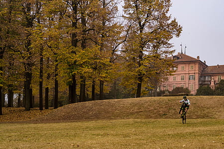 man cycling on green grass field thumbnail