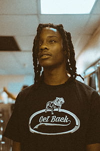 photograph of braid haired man in get back graphic shirt thumbnail