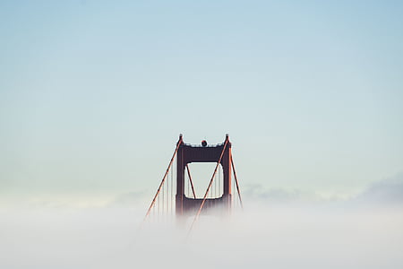 red metal bridge surrounded by clouds thumbnail
