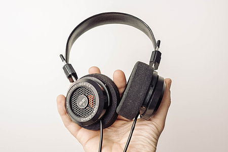 person holding black corded headphones thumbnail