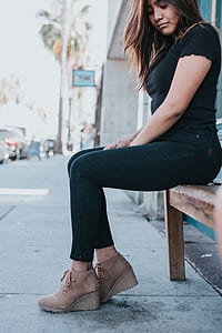 woman in black short-sleeved shirt sitting while looking down thumbnail