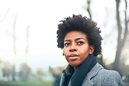 A young African woman with curly hair posing outdoors thumbnail