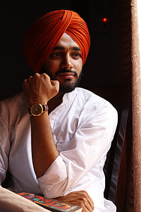 man in white dress shirt and orange turban wearing round gold-colored watch with brown leather strap thumbnail