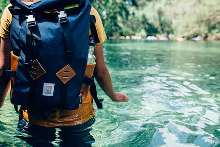 person wearing backpack on body of water thumbnail