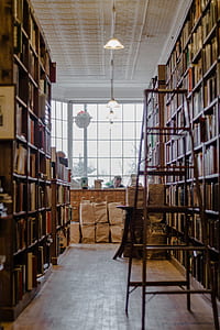 brown wooden A-frame ladder beside a bookshelf thumbnail