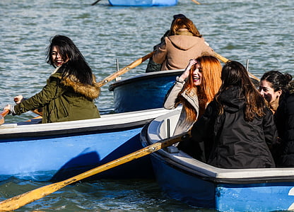 women riding on boat rowing towards each other thumbnail