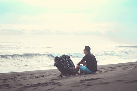 Two Man Sitting on the Sand Near the Beach thumbnail