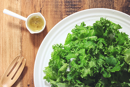 salad on white ceramic plate with sauce and wooden fork thumbnail