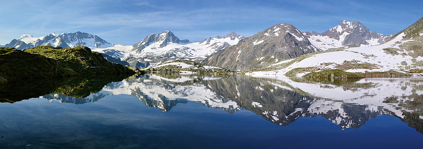 gray mountains across body of water under blue sky at daytime thumbnail