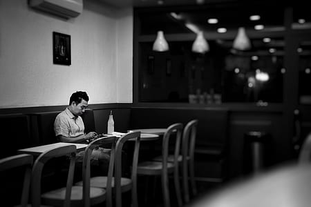 man sitting on dining chair in front of dining table inside restaurant thumbnail