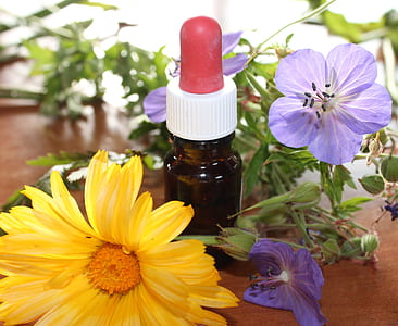 medicine drop bottle in between assorted flowers thumbnail