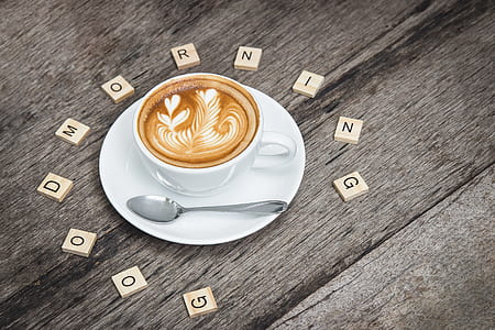 a cup of cappuccino with flower art and with scrabble letter words good morning greeting thumbnail