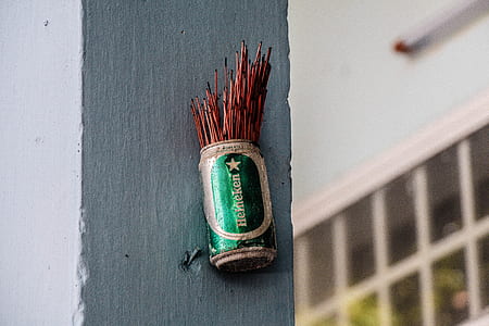 green Heineken can with brown sticks on wall thumbnail