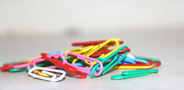 assorted-color plastic paper clips on white surface thumbnail