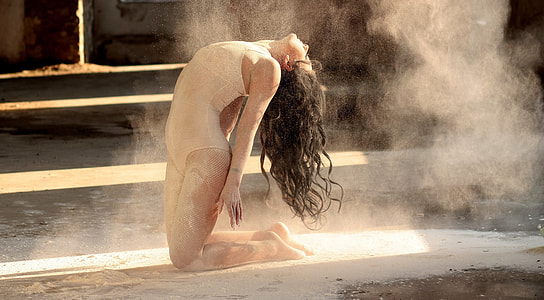 woman in leotards kneeling while bending head over back thumbnail