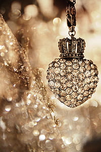 shallow focus photography of silver-colored heart pendant with clear gemstones thumbnail