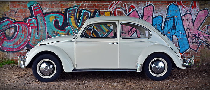 white Volkswagen Beetle parked beside wall thumbnail