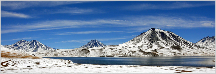 mountain coated with snow beside body of water thumbnail