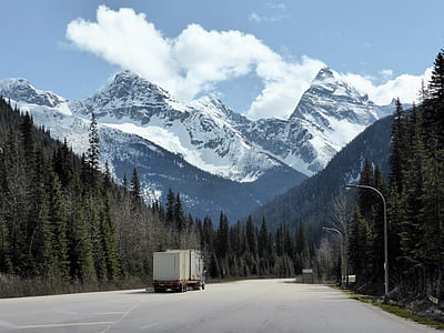 beige truck on road with scenery of mountain thumbnail