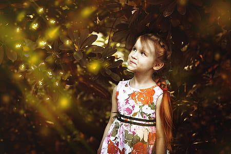 girl wearing white and orange sleeveless dress under green leaf tree thumbnail
