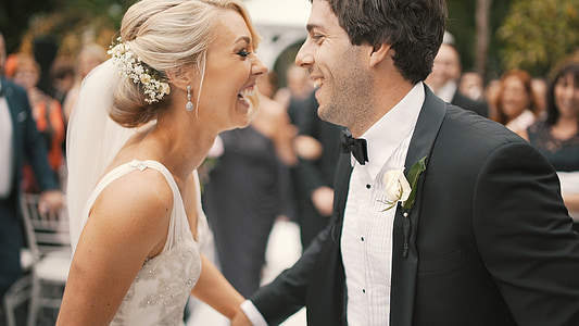 woman in white sleeveless bridal gown and man in black suit thumbnail