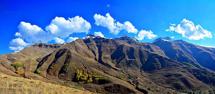photo of brown mountains under blue sky thumbnail