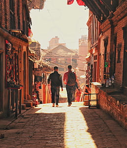 Two Man Walking Beside Brick Houses thumbnail