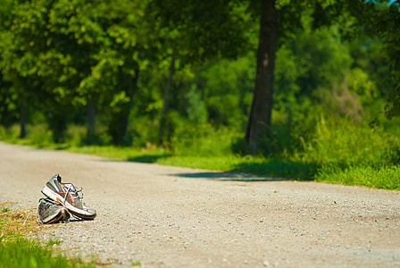 pair of gray and white running shoes on brown sand near at green grass during daytime thumbnail