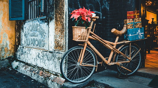 brown city bike parked beside black bricked building doorway thumbnail