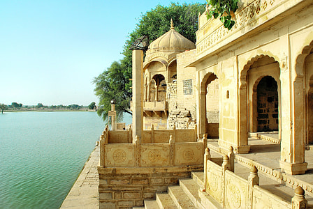 beige concrete building near trees and river thumbnail