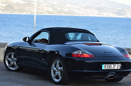 black Porsche Boxster soft-top coupe on gray pavement thumbnail