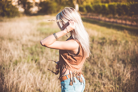 Young Boho Woman Enjoying Sun and Holding Flower Stem thumbnail