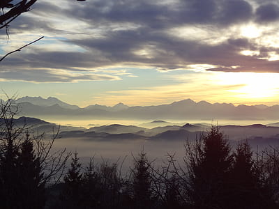 mountain surrounded with fogs during golden hour thumbnail