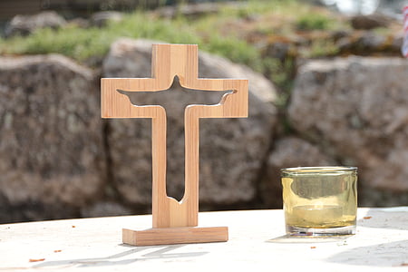 beige wooden cross beside glass candle holder thumbnail